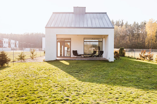 Modern Garden Furniture On The Terrace Of Stylish Suburban House With Big Green Yard