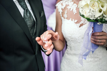 Young married couple holding hands, ceremony wedding day, wedding rings.