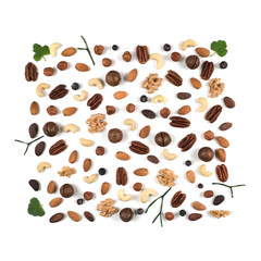 A pattern of nuts on a white background, decorated with green leaves. View to the top, there is a place for inscription.