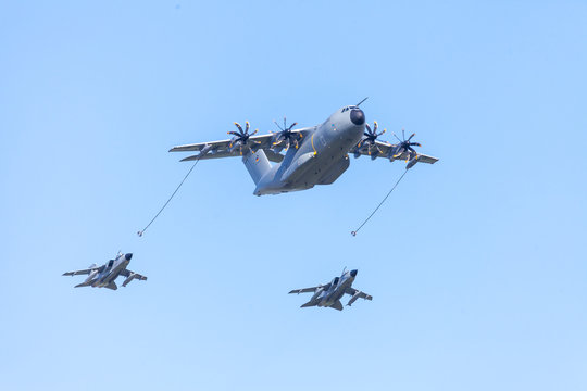 BERLIN / GERMANY - APRIL 28, 2018: Military Airbus A 400 M transport plane flies with two Panavia Tornado  multirole combat aircrafts at airfield Schoenefeld / Berlin.