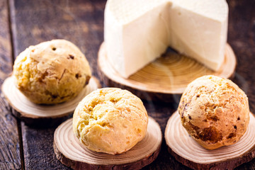 Brazilian cheese bread, hot, freshly made. Polvilho and Minas Gerais cheese in the background, on a rustic wooden box. Homemade, organic snack.