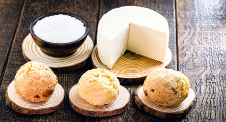 Brazilian cheese bread, hot, freshly made. Polvilho and Minas Gerais cheese in the background, on a rustic wooden box. Homemade, organic snack.