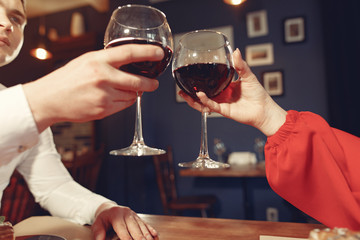 Couple in a restaurant. Lady in a red dress. Pair drinking a vine. Valentine's day.