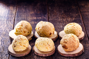 many Brazilian cheese breads, on rustic wooden background and space for text. Food made in minas gerais.