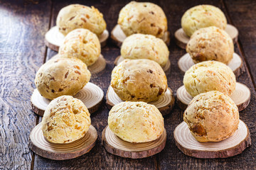 many Brazilian cheese breads, on rustic wooden background and space for text. Food made in minas gerais.