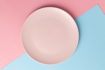 Empty pink plate on blue and pink pastel background