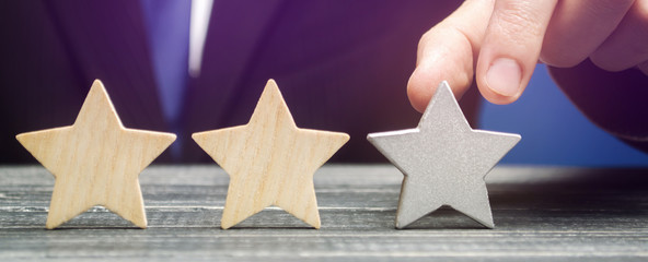 Critic points to third star. The concept of the rating of hotels and restaurants. The evaluation of visitors. Quality level, good service. Customer rating. Feedback.