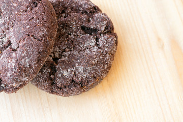 Top close up view of chocolate cookies on wooden table.Freshly baked choco biscuites.