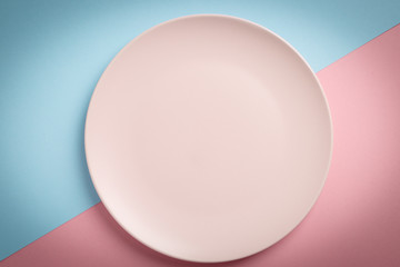 Empty pink plate on blue and pink pastel background