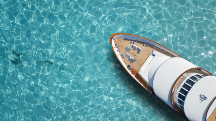Aerial drone top down photo of luxury exotic yacht nose with wooden deck anchored in paradise...
