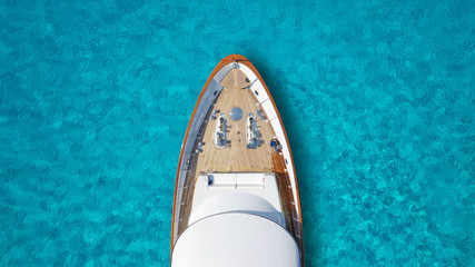 Fototapeta na wymiar Aerial drone top down photo of luxury exotic yacht nose with wooden deck anchored in paradise turquoise bay