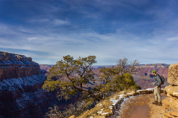 Fototapeta na wymiar man tourist backpacker on a trail winter landscape of Grand Canyon National Park's South Rim