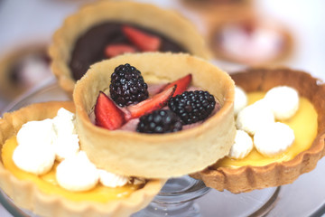 tartaletas y pasteles de frutas en mesa blanca 