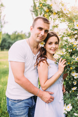 Portrait of a happy couple in love with flowers, hugs, love story, sunny photo