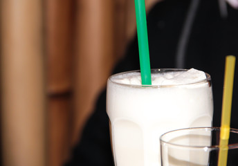 Milkshake with a green straw. Milk drink.