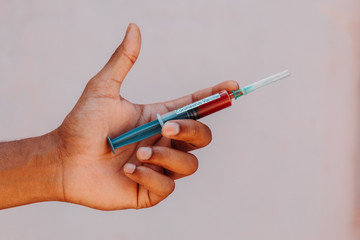 Hand holding an injection containing the Coronavirus vaccine