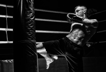 Kickboxer hits the bag with his knee. Training a professional athlete. The concept of mma,...