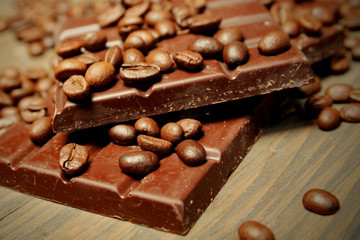 Dark chocolate and coffee beans on table