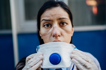 Exhausted doctor / nurse taking of coronavirus protective gear N95 mask uniform.Coronavirus...