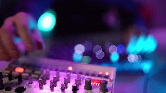 Close up shot of hand's man DJ playing music at home recording studio workshop. Student learns to write creative atmosphere music. Online education training. Sound beat maker. Colorful Neon light