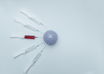 On a blue background lies a ball in the form of a coronavirus infection, around which there are...