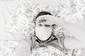 mask male lies at home in bed and taking a selfie