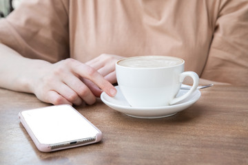 On the table a woman's hand, a Cup of coffee and phone. Mock up. Cooking, food delivery, cafe, restaurant, cheese Factory, cheese tasting
