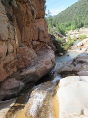 View over the Ellison Creek waterfall with unrecognizable tourists and locals below on the Water Wheel Falls hiking trail in Payson, Arizona