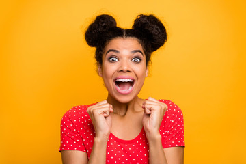 Portrait excited astonished afro american girl hear incredible information about dream present she get on anniversary raise fists scream yes wear red outfit isolated shine color background