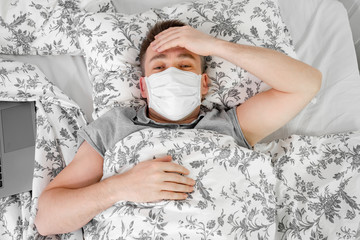 masked man lies at home in bed and sick. stay home