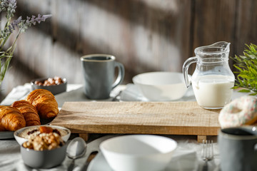 Breakfast on a wooden table in the light of the morning sun on a beautiful holiday day