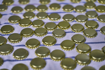 Metal beer caps in line on cloth in a brewery