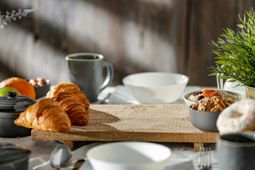 Breakfast on a wooden table in the light of the morning sun on a beautiful holiday day