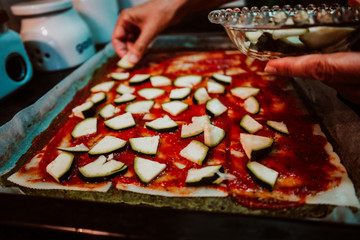 .Middle-aged woman preparing a healthy pizza based on fresh food. Cooking at home relaxed and unhurried. Stay home