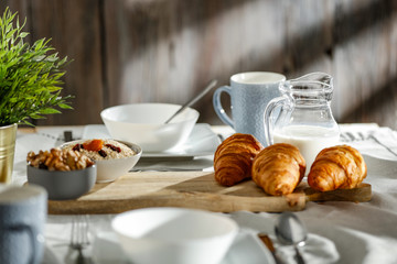 Breakfast on a wooden table in the light of the morning sun on a beautiful holiday day