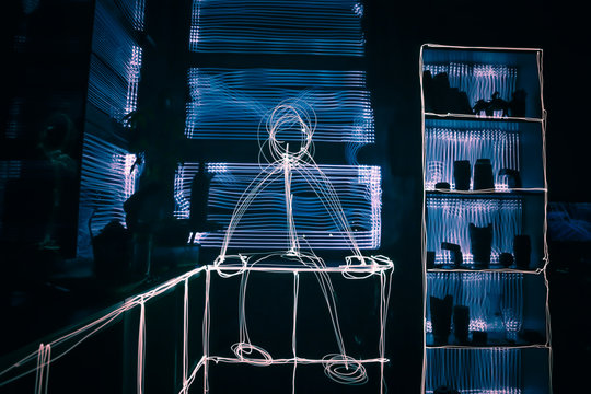 Light Painting  Of A Stickman Sitting In The Room With Long Exposure Photography.