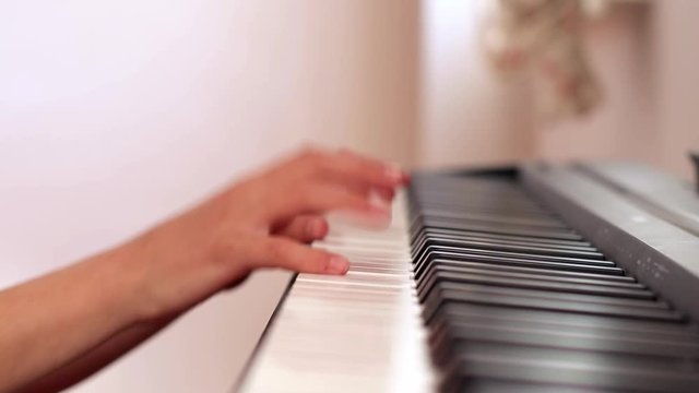 Close uo child's hand playing piano at home,right up piano
