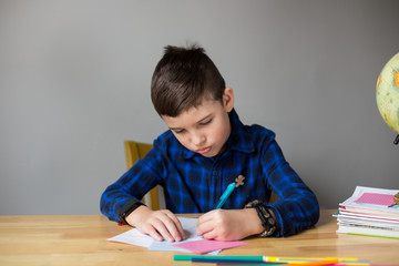 Cute boy learning at home during covid-19 coronavirus quarantine.