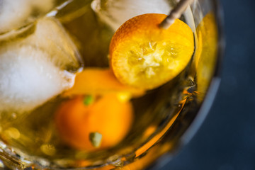Whisky with ice and kumquat fruit
