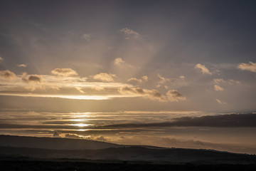 Sun rays bursting through the sky over countryside