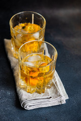 Whisky with ice and kumquat fruit