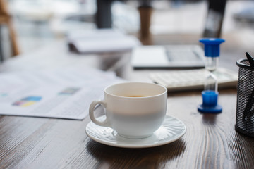 White cup of coffee on table in office