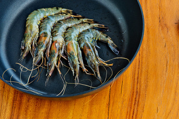 Fresh shrimps in a frying pan. Close-up. Kitchen background.