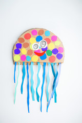 Cardboard octopus with colorful ribbons on a white background.
