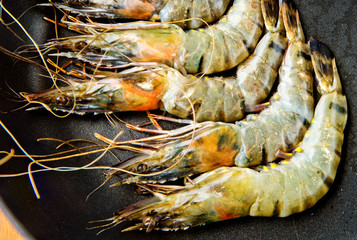 Fresh shrimps in a frying pan. Close-up. Kitchen background.