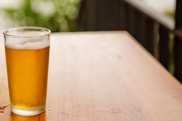 Glass of beer on a wooden table. Close up.