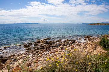 Beautiful seascape with calm sea, pebbles beach, blue sky of suburb in South Athens located in the Athens Riviera, Greece in spring.