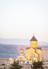View from distance to new New Makhata Iveron Icon of the Mother of God church  in Tbilisi with mountains in the background. Georgia.Churches in Caucasus 2020.