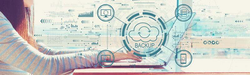 Backup concept with woman working on a laptop in brightly lit room
