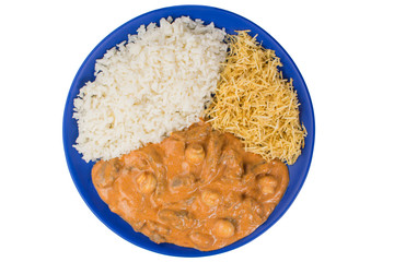 Brazilian tenderloin stroganoff with rice and potato sticks in a blue plate isolated  in white background seen from above